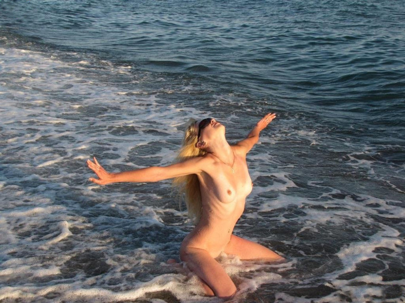 Голая девушка купается в море в жару