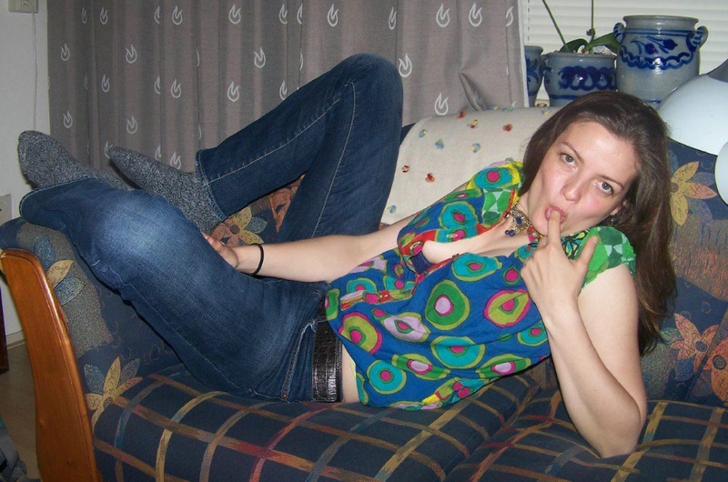Молодая девка у себя дома на диване показывает сиськи и пизду