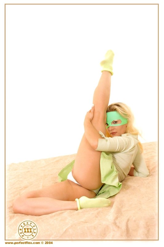 Очень гибкая блондинка в зеленой маске широко раздвигает ноги
